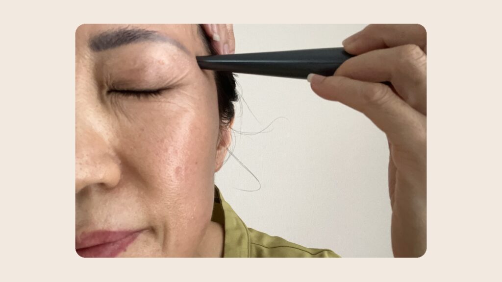 こめかみにエフェクトロッドを押し当てる